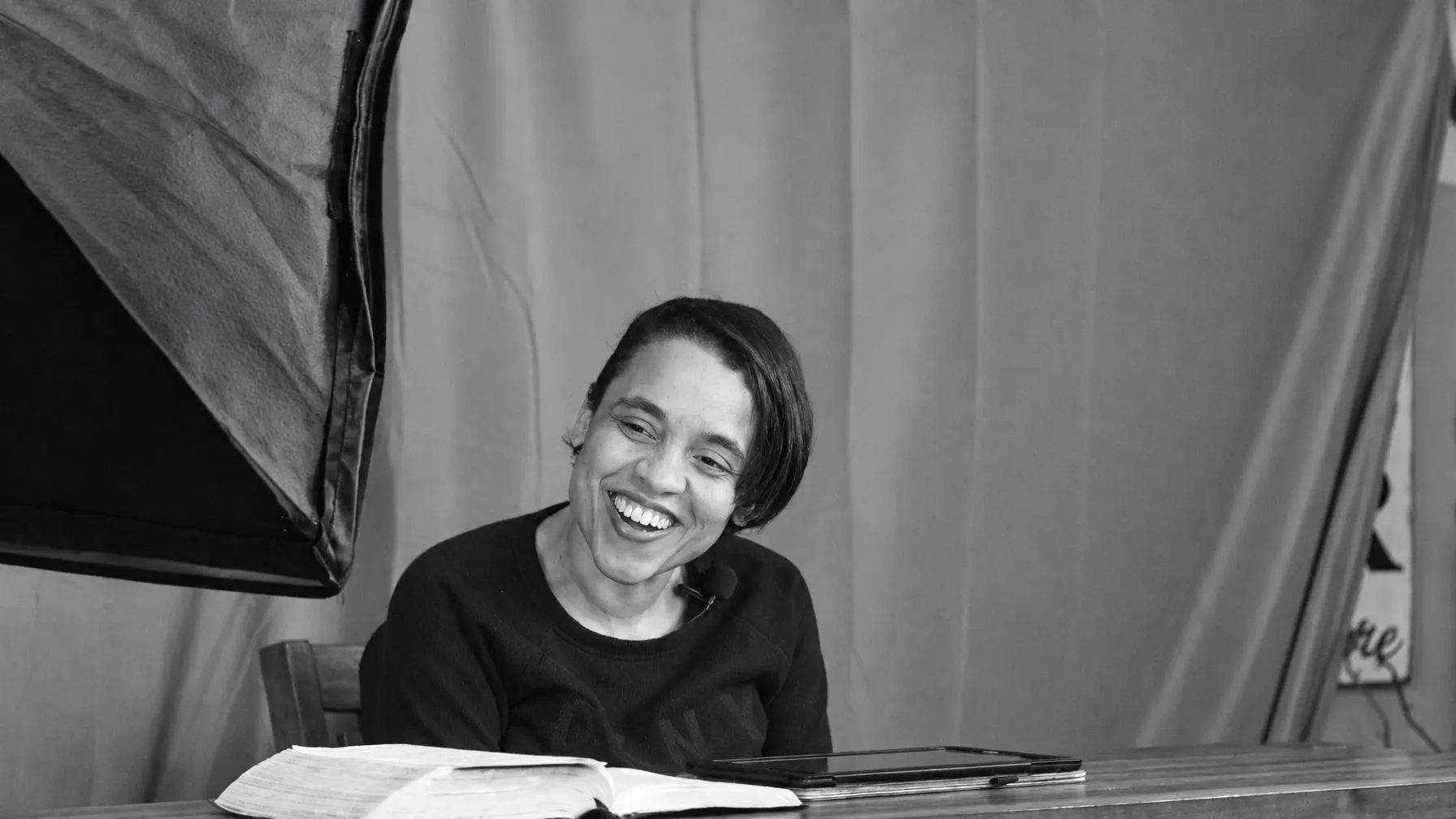 A ministry member smiling during a moment of Bible study and video recording
